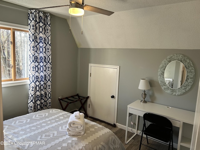 bedroom featuring lofted ceiling, ceiling fan, a textured ceiling, and wood finished floors