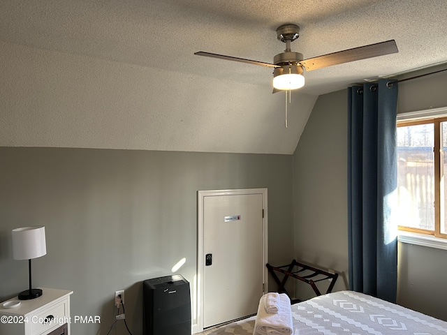 bedroom with lofted ceiling, ceiling fan, and a textured ceiling