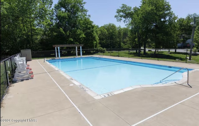 pool featuring a patio area and fence