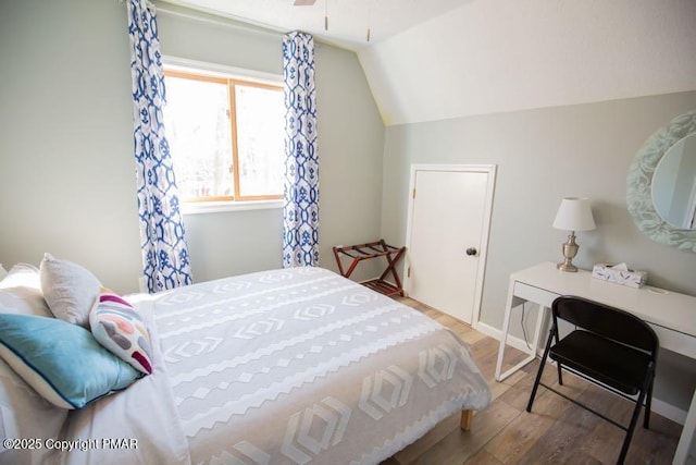 bedroom with lofted ceiling and wood finished floors