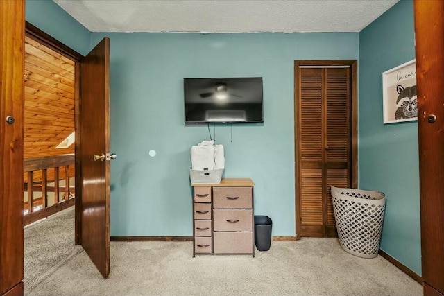 bedroom with carpet floors, a closet, a textured ceiling, and baseboards