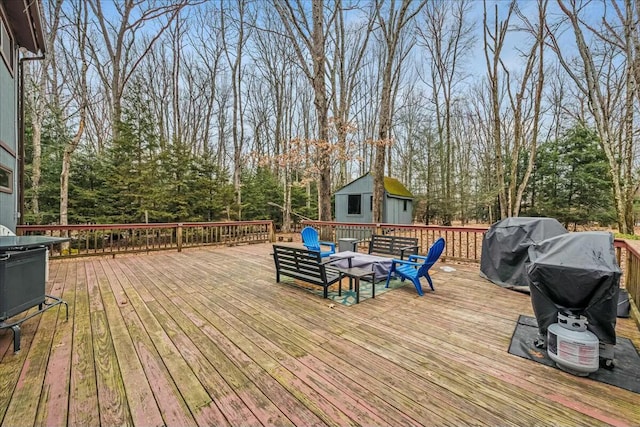 wooden terrace with an outdoor structure and area for grilling