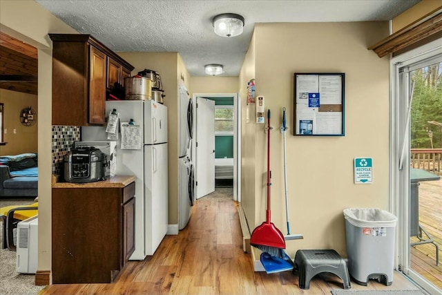 kitchen with light wood-style floors, freestanding refrigerator, a healthy amount of sunlight, and a textured ceiling