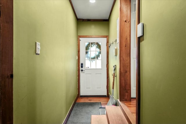 doorway with wood finished floors and baseboards