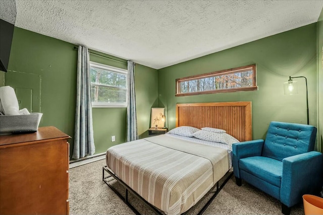 carpeted bedroom featuring a textured ceiling and a baseboard radiator