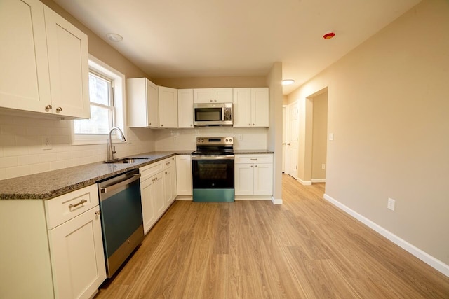 663 Sullivan Trl, Long Pond, PA 18334 - kitchen featuring appliances with stainless steel finishes, a sink, light wood-type flooring, backsplash, and white cabinetry