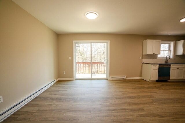 663 Sullivan Trl, Long Pond, PA 18334 - unfurnished living room featuring a baseboard heating unit, baseboards, dark wood finished floors, and a sink