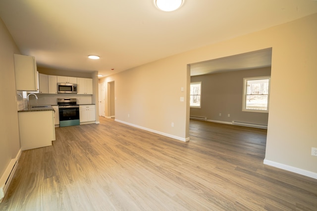 663 Sullivan Trl, Long Pond, PA 18334 - unfurnished living room featuring a baseboard radiator, baseboard heating, and wood finished floors