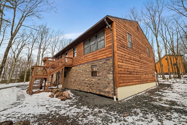 view of snowy exterior with a wooden deck