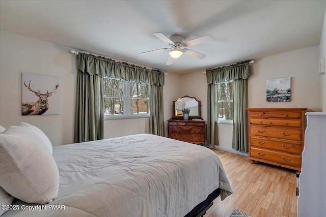 bedroom with light hardwood / wood-style flooring and ceiling fan