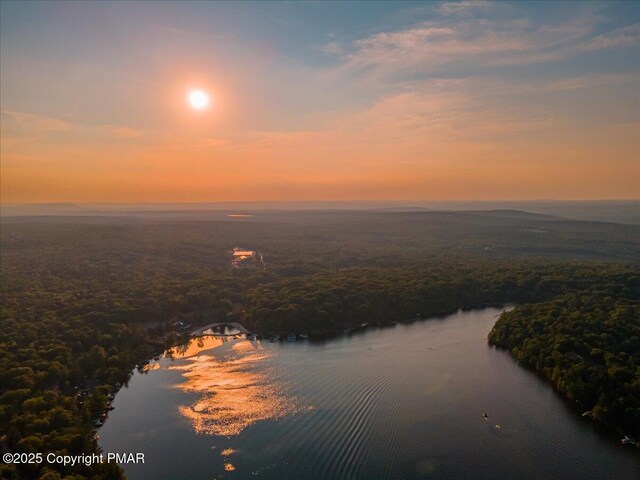 aerial view at dusk featuring a water view