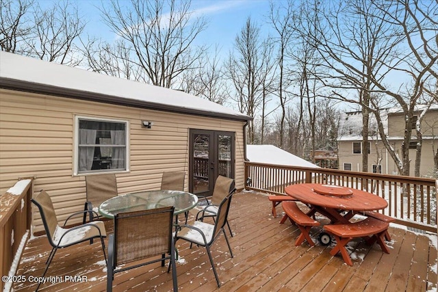 snow covered deck with french doors