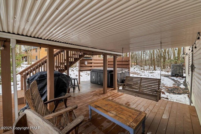 snow covered deck with cooling unit and a hot tub