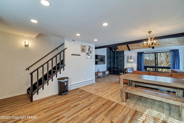 dining room featuring wood finished floors, a wood stove, stairs, a notable chandelier, and recessed lighting