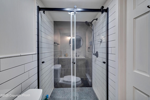 bathroom with toilet, a stall shower, and tile walls