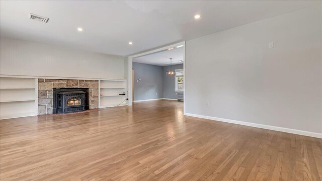 2705 W Gordon St, Allentown, PA 18104 - unfurnished living room with wood finished floors, recessed lighting, a tile fireplace, and built in shelves