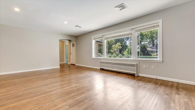 2705 W Gordon St, Allentown, PA 18104 - spare room with radiator, light wood-style flooring, arched walkways, and recessed lighting