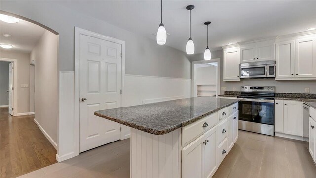2705 W Gordon St, Allentown, PA 18104 - kitchen featuring stainless steel appliances, arched walkways, a kitchen island, white cabinetry, and dark stone countertops