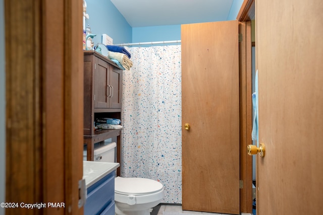 bathroom featuring a shower with shower curtain, vanity, and toilet