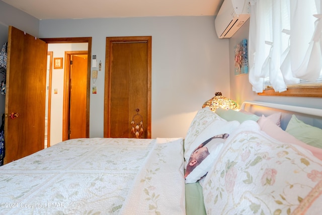 bedroom with an AC wall unit and a closet