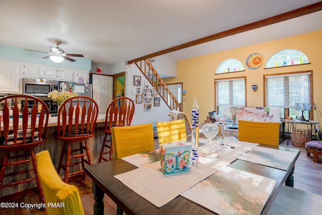 dining space featuring stairs, wood finished floors, and a ceiling fan