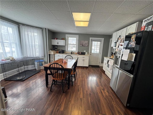 dining room with a drop ceiling and dark hardwood / wood-style floors