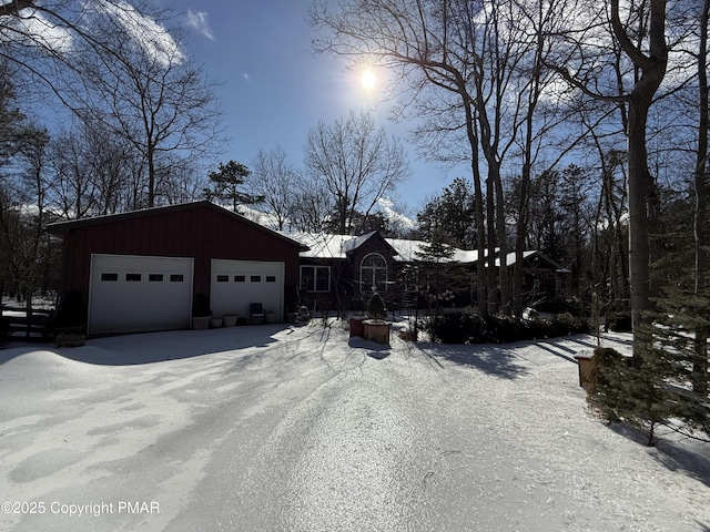 view of snow covered exterior featuring an attached garage