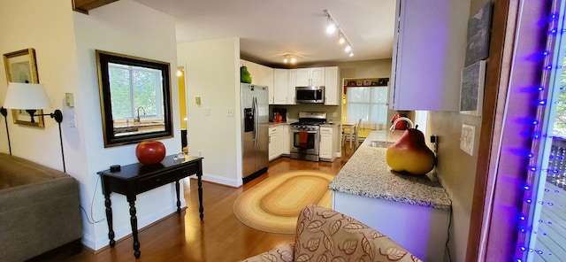 210 Dover Dr, Bushkill, PA 18324 - kitchen featuring appliances with stainless steel finishes, light wood-style flooring, white cabinetry, light stone counters, and rail lighting