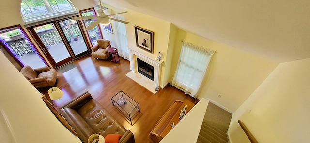 210 Dover Dr, Bushkill, PA 18324 - living area featuring wood finished floors, a fireplace with flush hearth, a towering ceiling, and ceiling fan