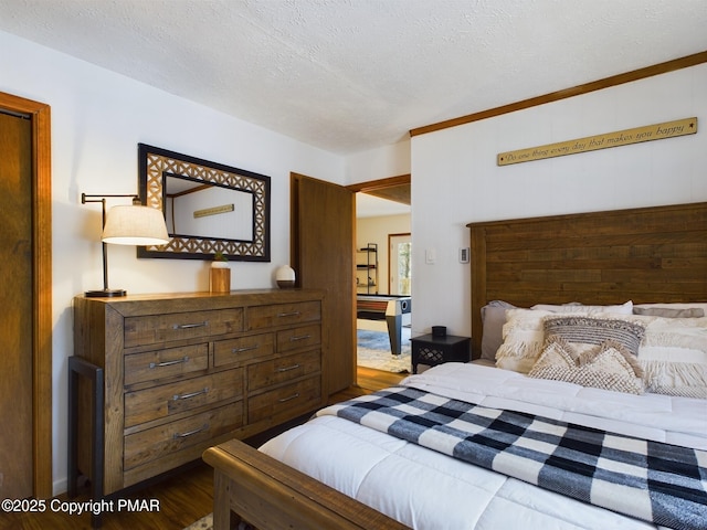 bedroom with dark hardwood / wood-style floors and a textured ceiling