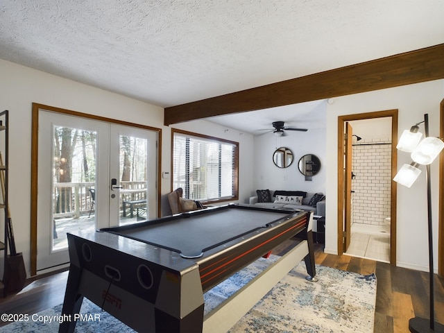 rec room featuring hardwood / wood-style flooring, a healthy amount of sunlight, a textured ceiling, and beam ceiling