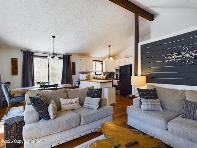 living room with dark wood-type flooring, lofted ceiling with beams, a textured ceiling, and a wealth of natural light