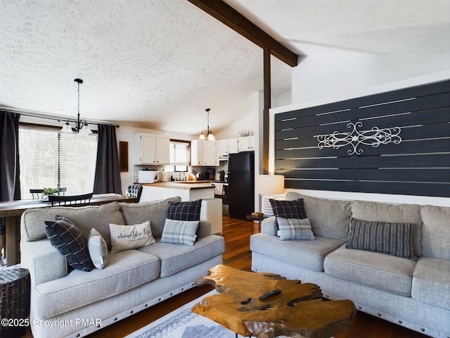 living room with vaulted ceiling with beams, dark hardwood / wood-style floors, and a textured ceiling