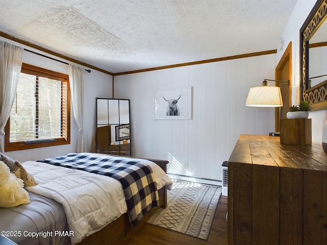 bedroom featuring ornamental molding, dark hardwood / wood-style floors, and a textured ceiling