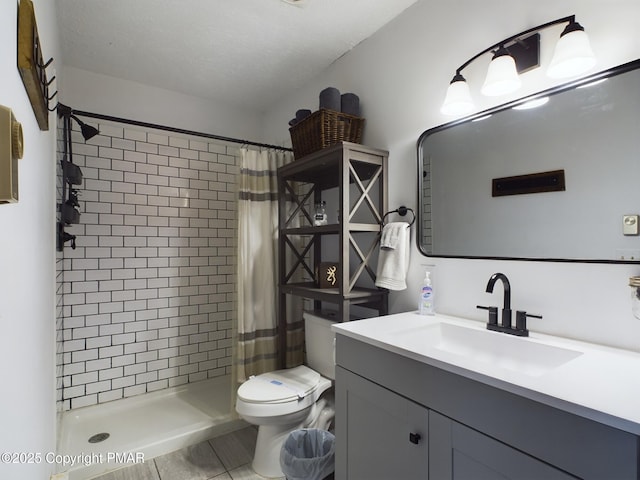 bathroom with walk in shower, vanity, toilet, and a textured ceiling