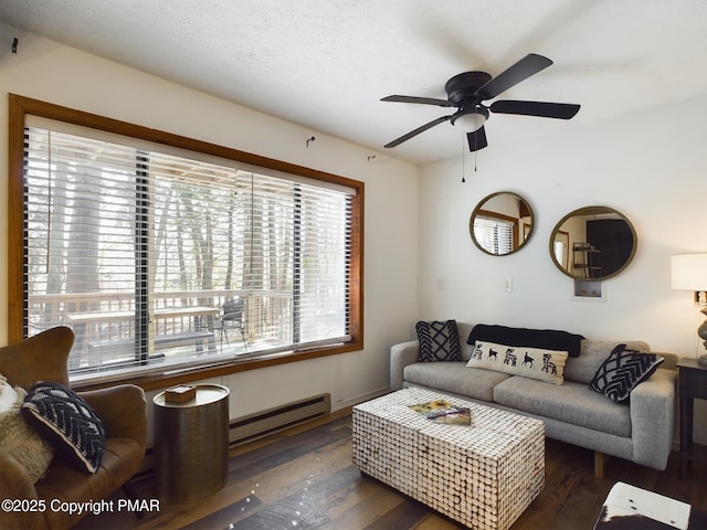 living room with dark wood-type flooring, a baseboard radiator, ceiling fan, and a textured ceiling