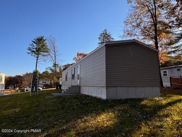 view of property exterior featuring entry steps and a lawn