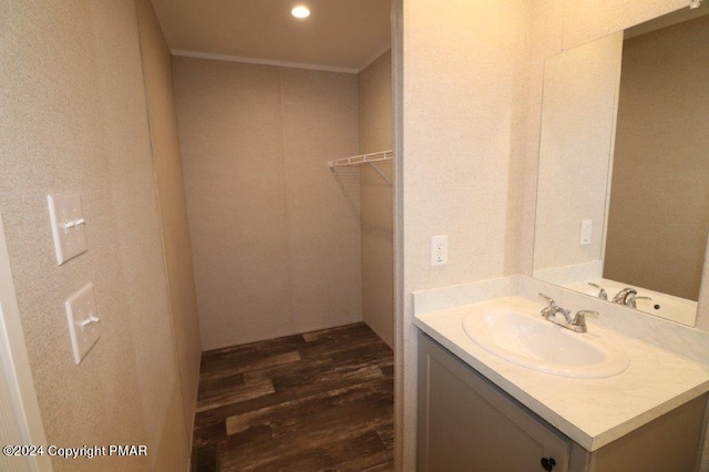 bathroom with crown molding, vanity, and wood finished floors