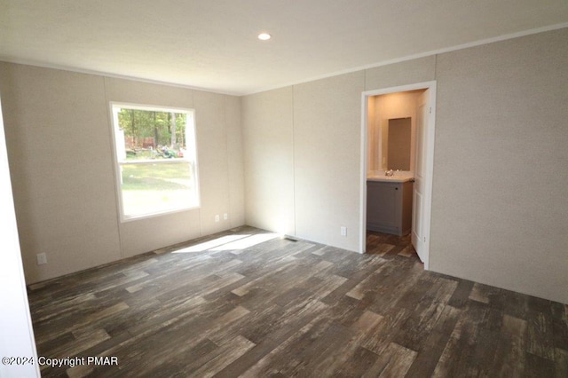 unfurnished room featuring dark wood-style flooring and a sink