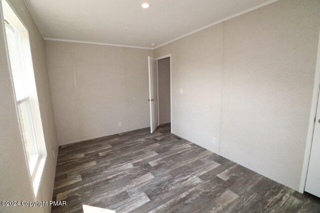 spare room featuring wood finished floors and crown molding