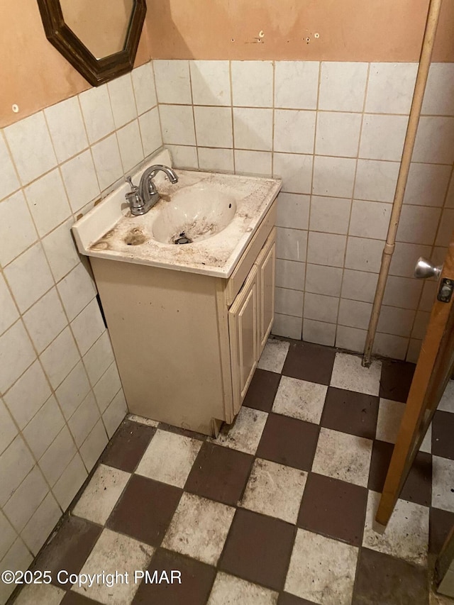 bathroom with vanity and tile walls