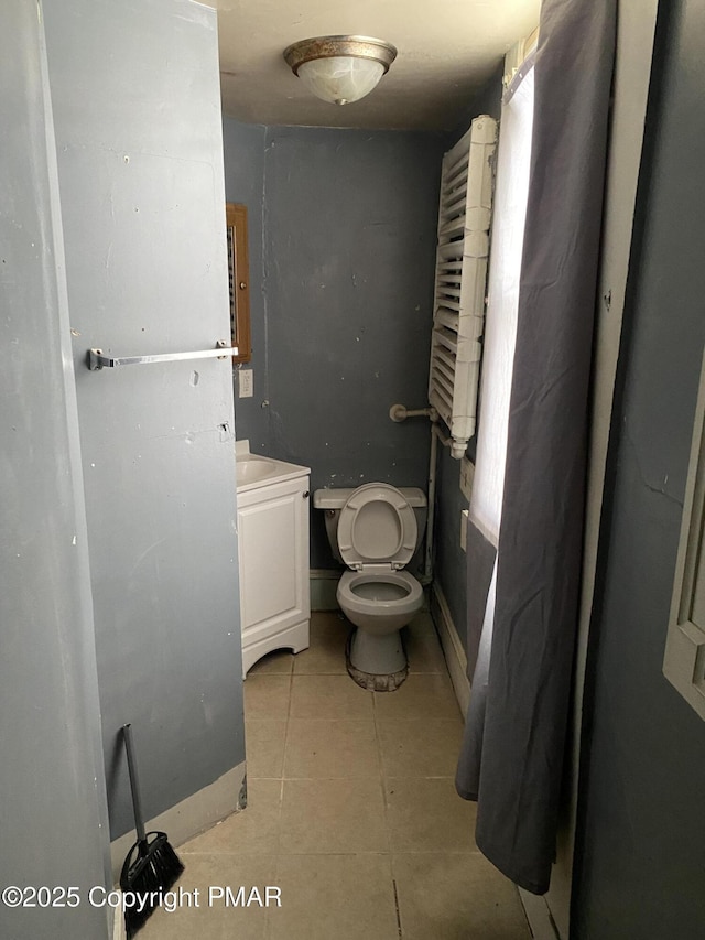 bathroom with tile patterned flooring, vanity, and toilet