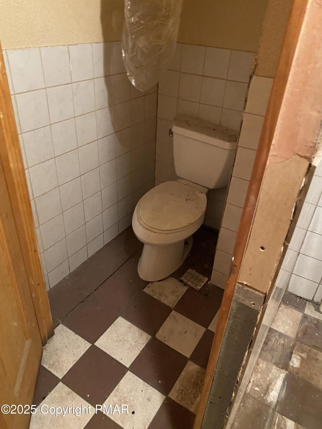 bathroom with tile walls and toilet