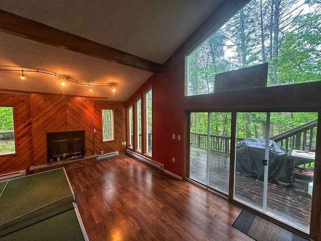 207 Manchester Dr, Bushkill, PA 18324 - unfurnished living room featuring a baseboard heating unit, wood walls, wood finished floors, healthy amount of natural light, and beamed ceiling