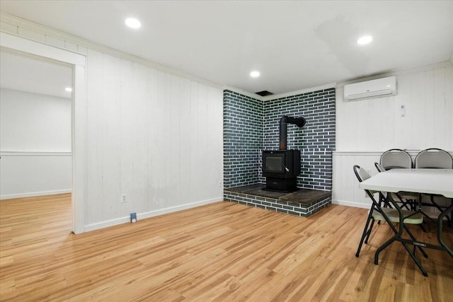 52 Bull Pine Rd, East Stroudsburg, PA 18301 - dining area with a wall mounted AC, wood finished floors, and a wood stove
