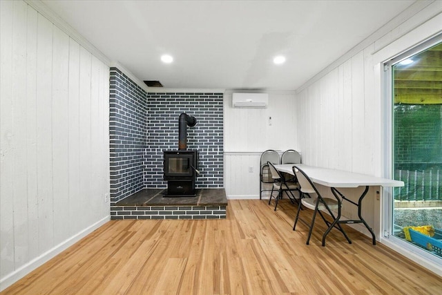 52 Bull Pine Rd, East Stroudsburg, PA 18301 - living area featuring a wall mounted AC, wood finished floors, a wood stove, wood walls, and ornamental molding