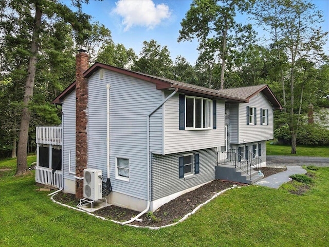 52 Bull Pine Rd, East Stroudsburg, PA 18301 - rear view of house with a chimney, a lawn, and view of scattered trees