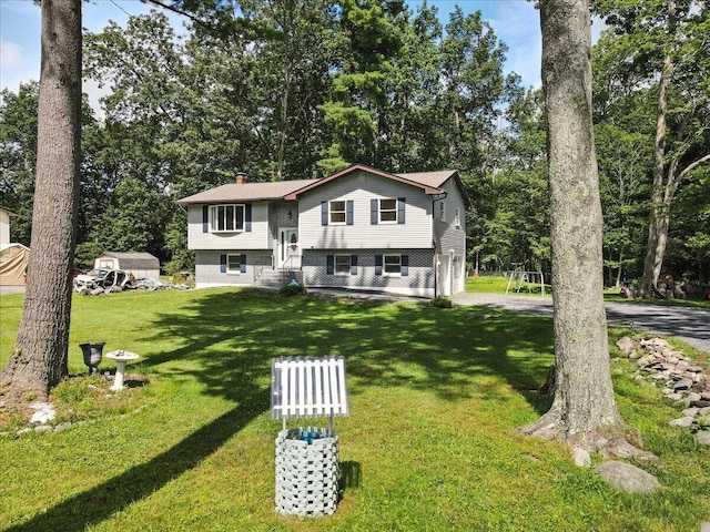 52 Bull Pine Rd, East Stroudsburg, PA 18301 - bi-level home featuring a chimney, a front yard, driveway, an attached garage, and view of wooded area