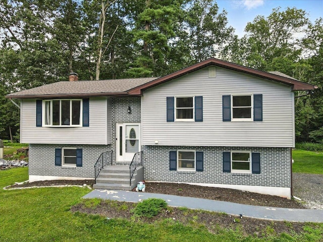 52 Bull Pine Rd, East Stroudsburg, PA 18301 - split foyer home featuring brick siding, a chimney, a front yard, and view of scattered trees