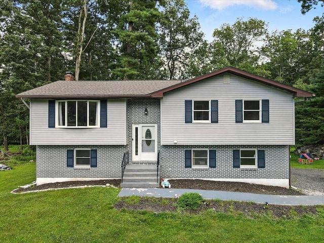 52 Bull Pine Rd, East Stroudsburg, PA 18301 - split foyer home with brick siding, a front yard, a chimney, and view of scattered trees